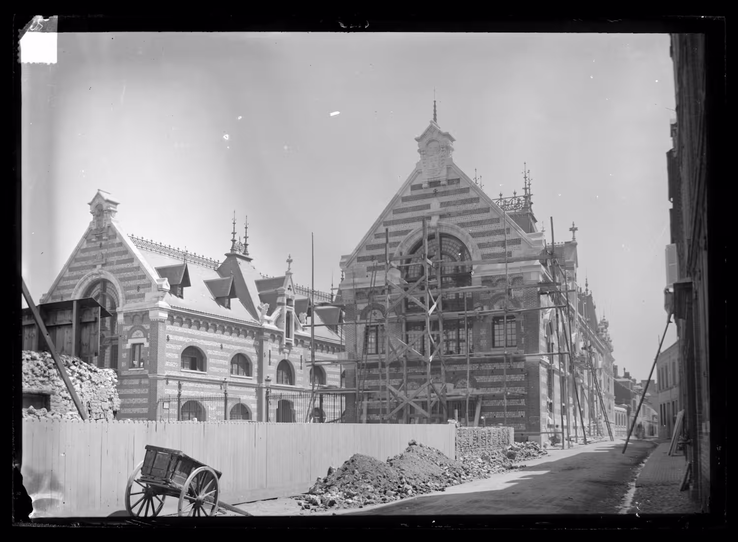 Historic photograph of the Palais Bénédictine under construction around 1880, with scaffolding on the main façade.